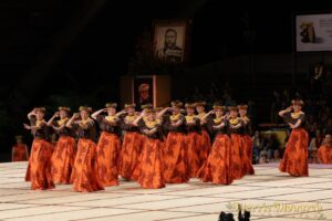 Group of dancers in long orange and brown dresses