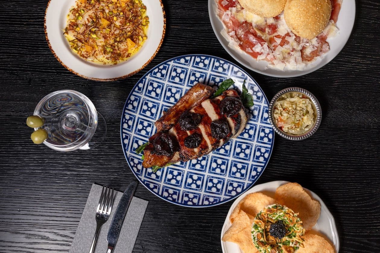 Food and cocktails on a black table.