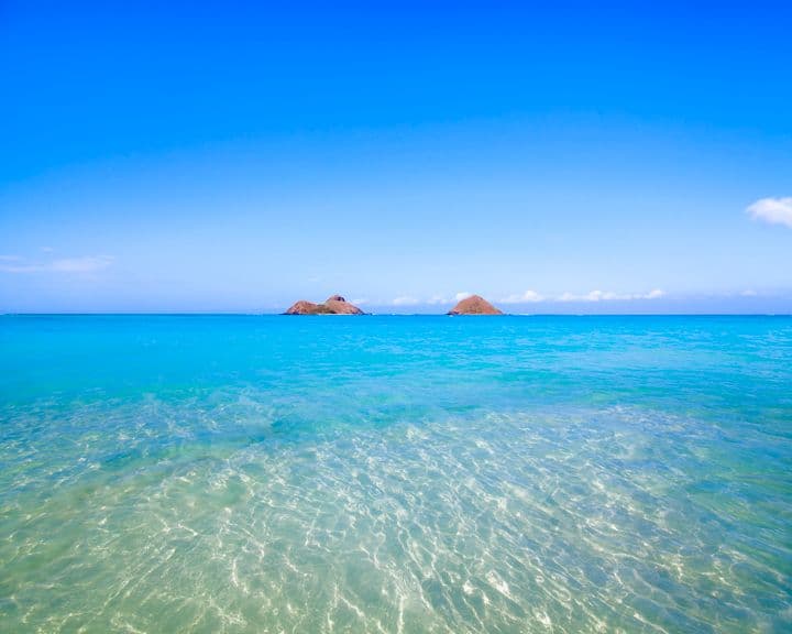 Ocean waters, small islets and blue skies over Lanikai Beach on Oahu.