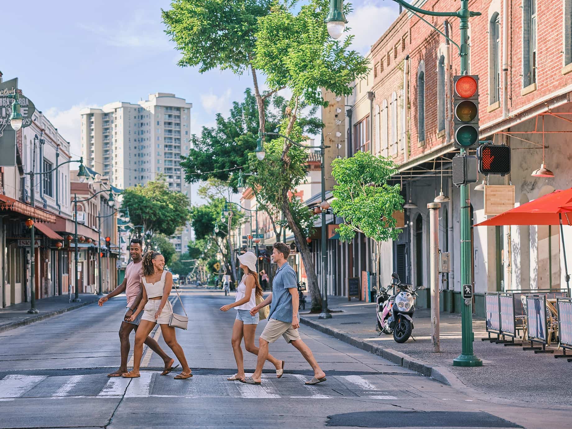 A group of friends walking across Hotel Street in Chinatown, Honolulu, Oahu Hawaii.