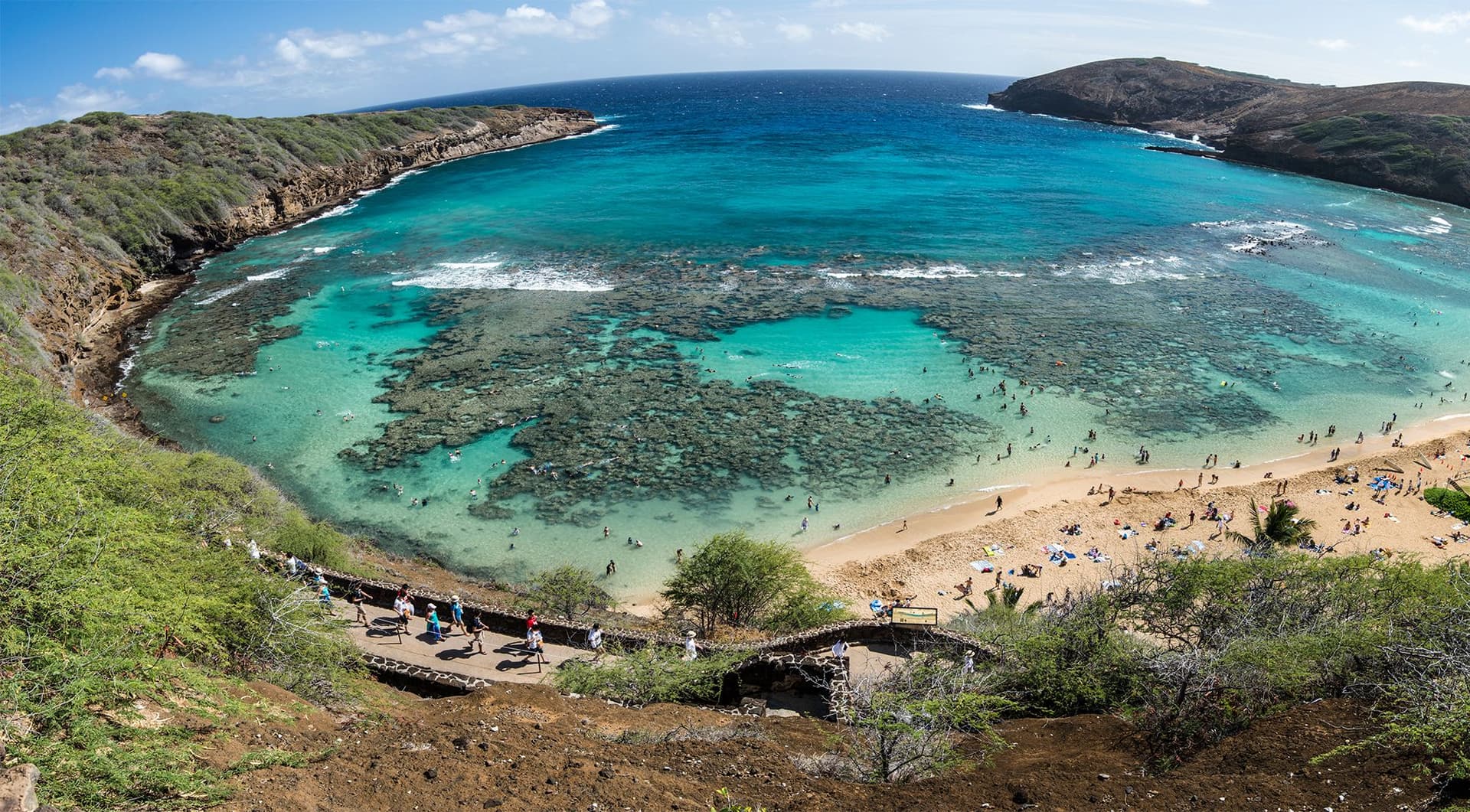 crescent shaped bay with turquoise water in a volcanic tuff cone