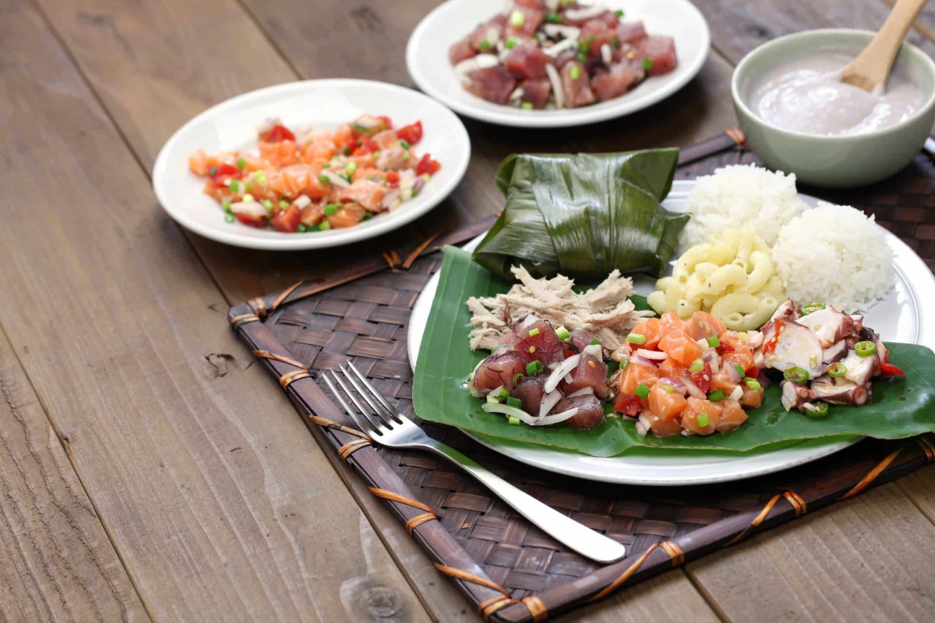 Traditional plate lunch: ahi poke, lomi lomi salmon, tako poke, kālua pork, poi, lau lau. Photo by Shutterstock.