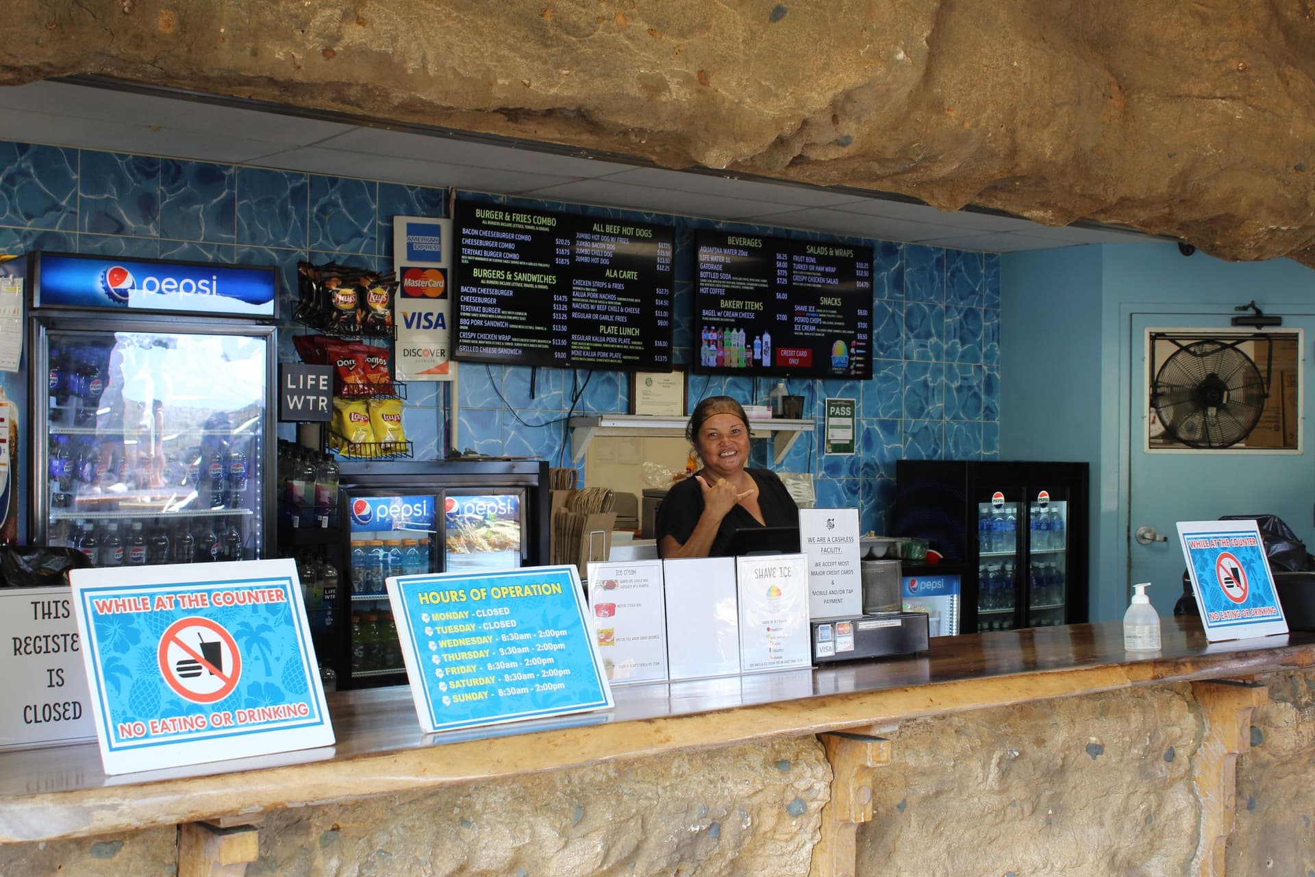 A woman behind a concession stand, snack shop