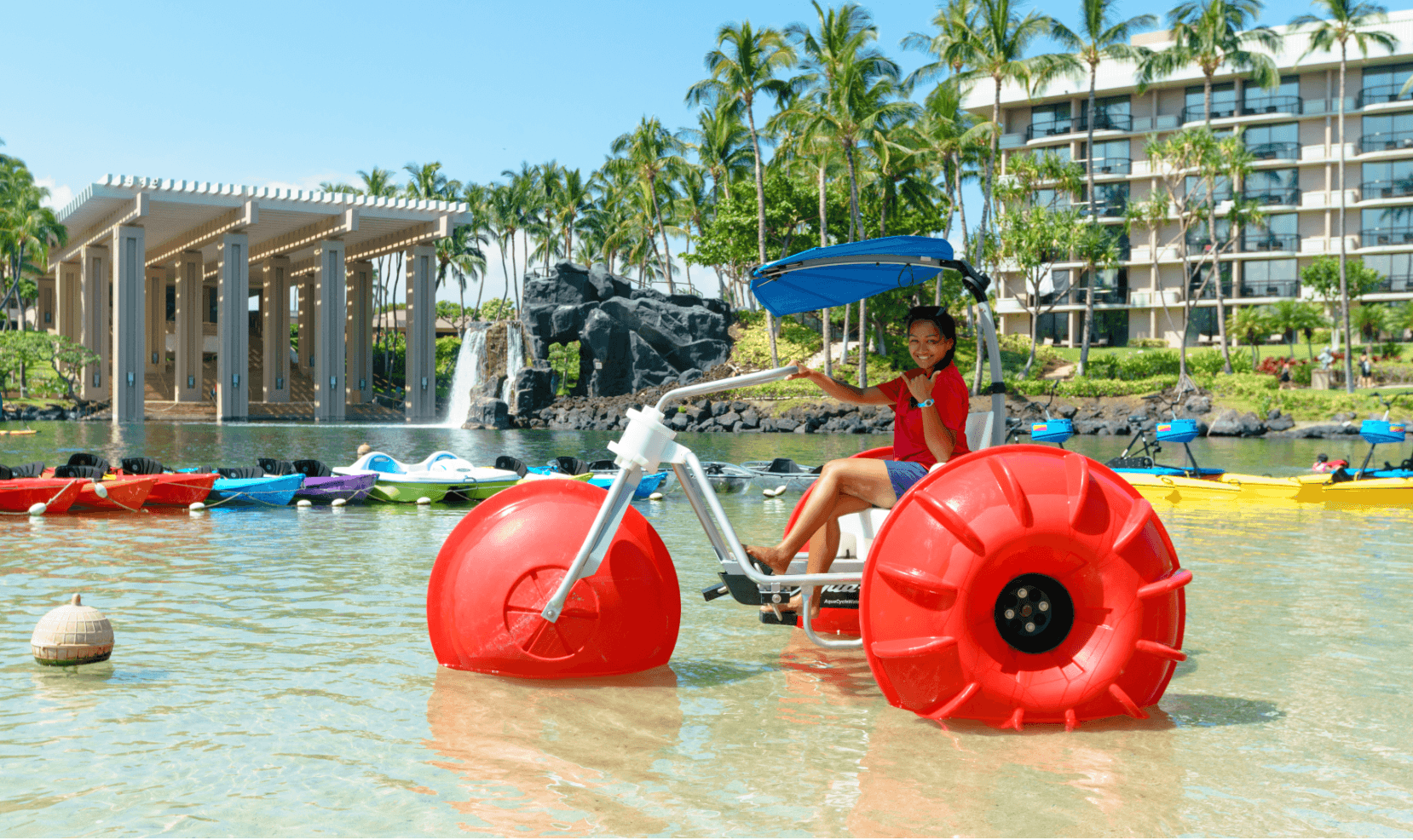 Kid on bike boat in a resort pool