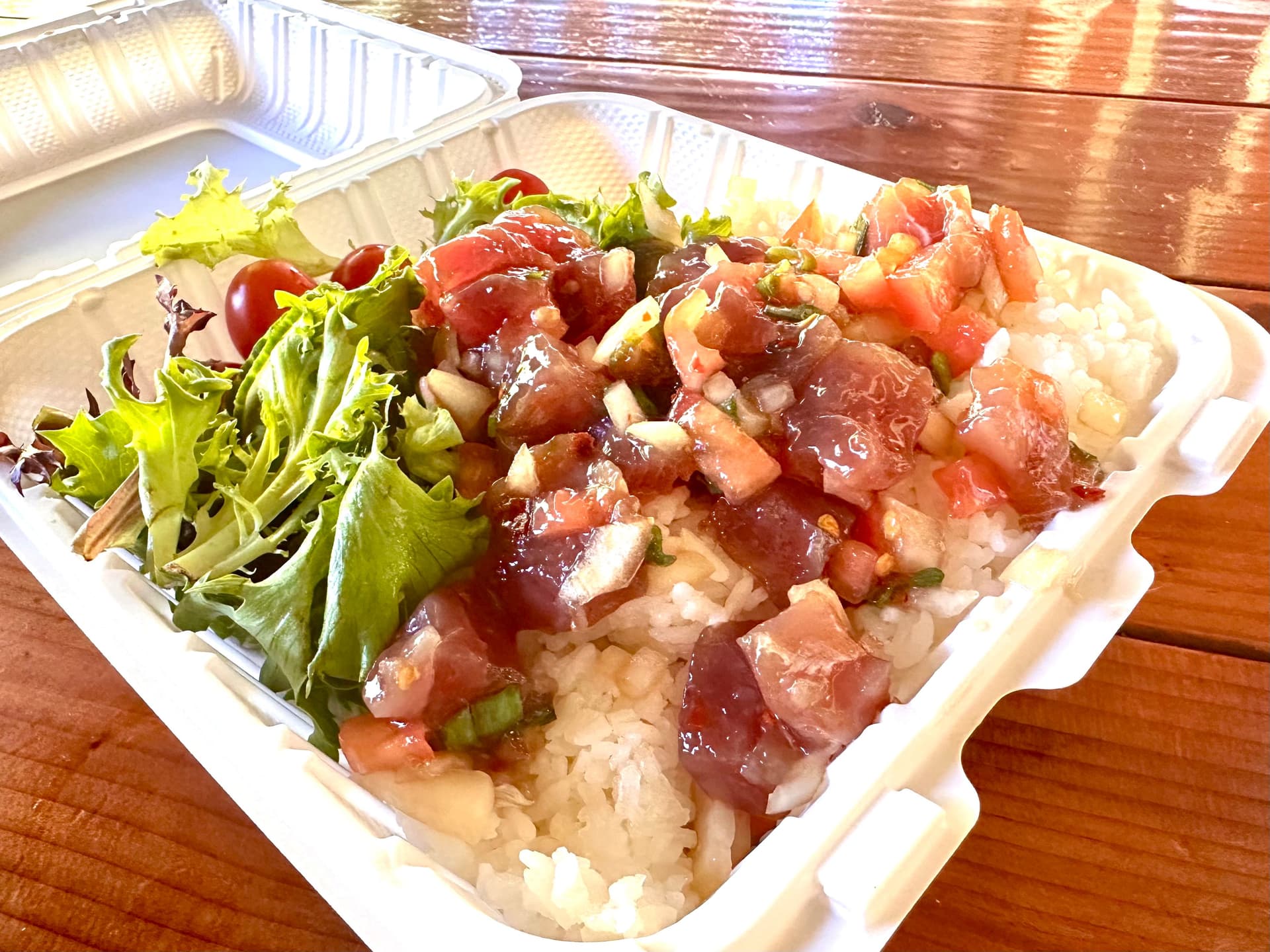 White clamshell container of ahi poke, white rice and salad.