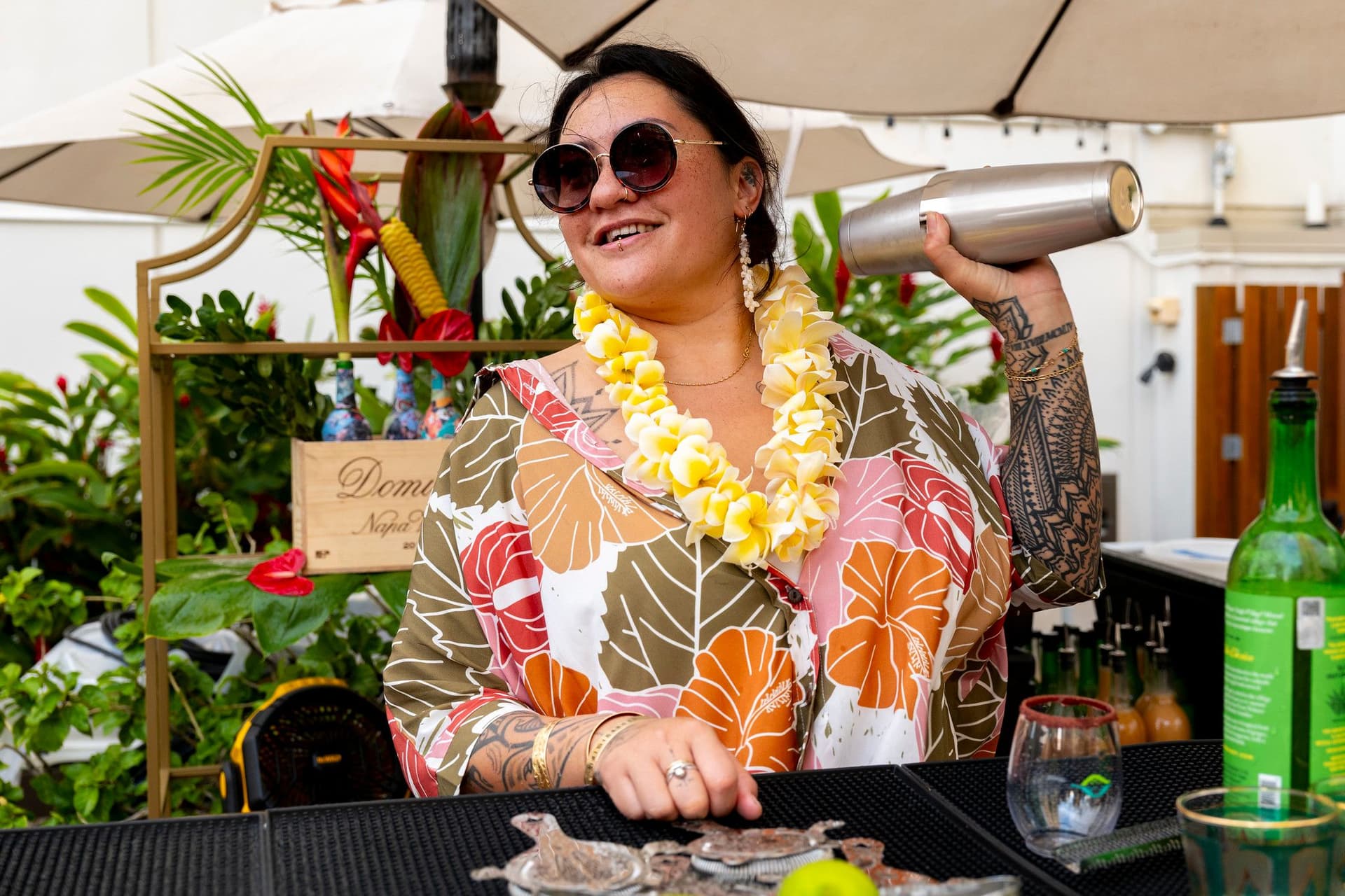 Woman shaking cocktail shaker at event.