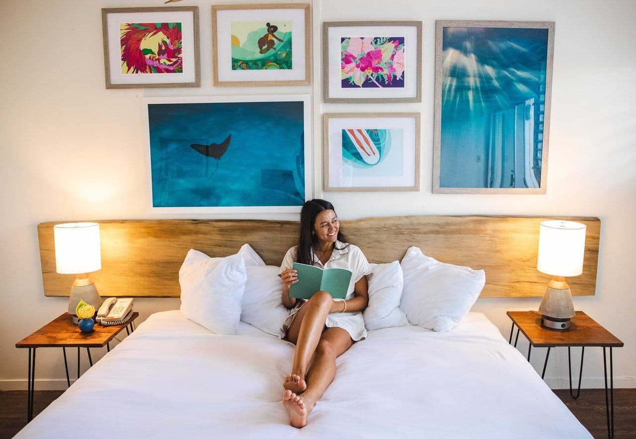 Woman lying on a bed reading in a hotel room