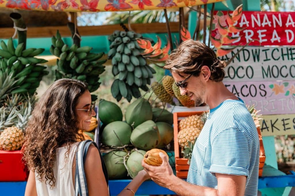 A couple buying tropical fruit from a stand on Maui Hawaii.
