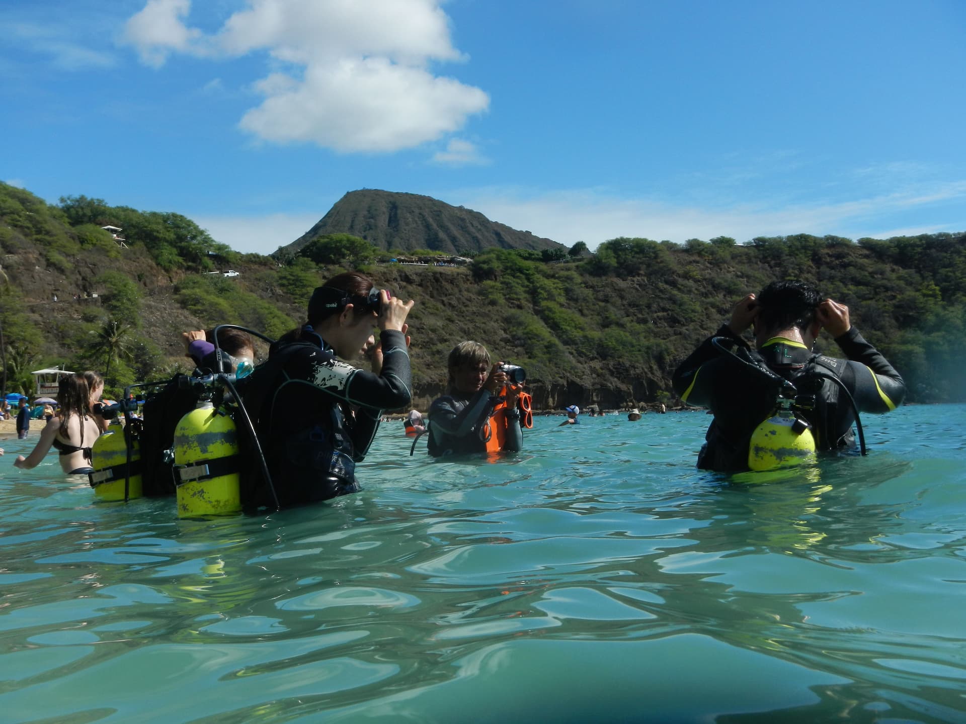 Snorkelers putting on face masks in the ocean.