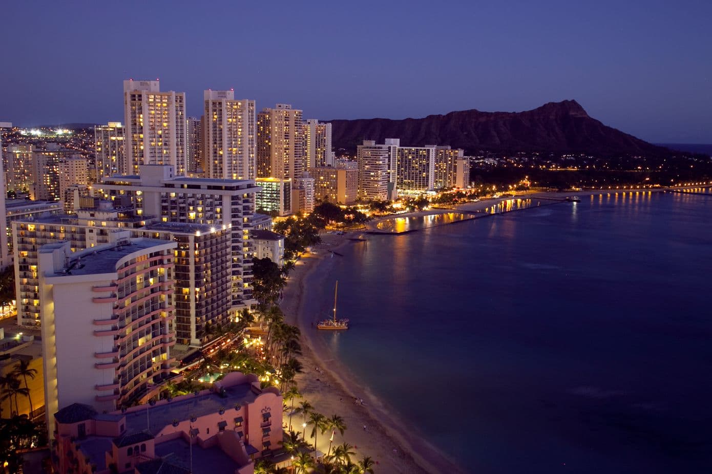 Waikiki at night with city lights, ocean and diamond head view on oahu, hawaii.