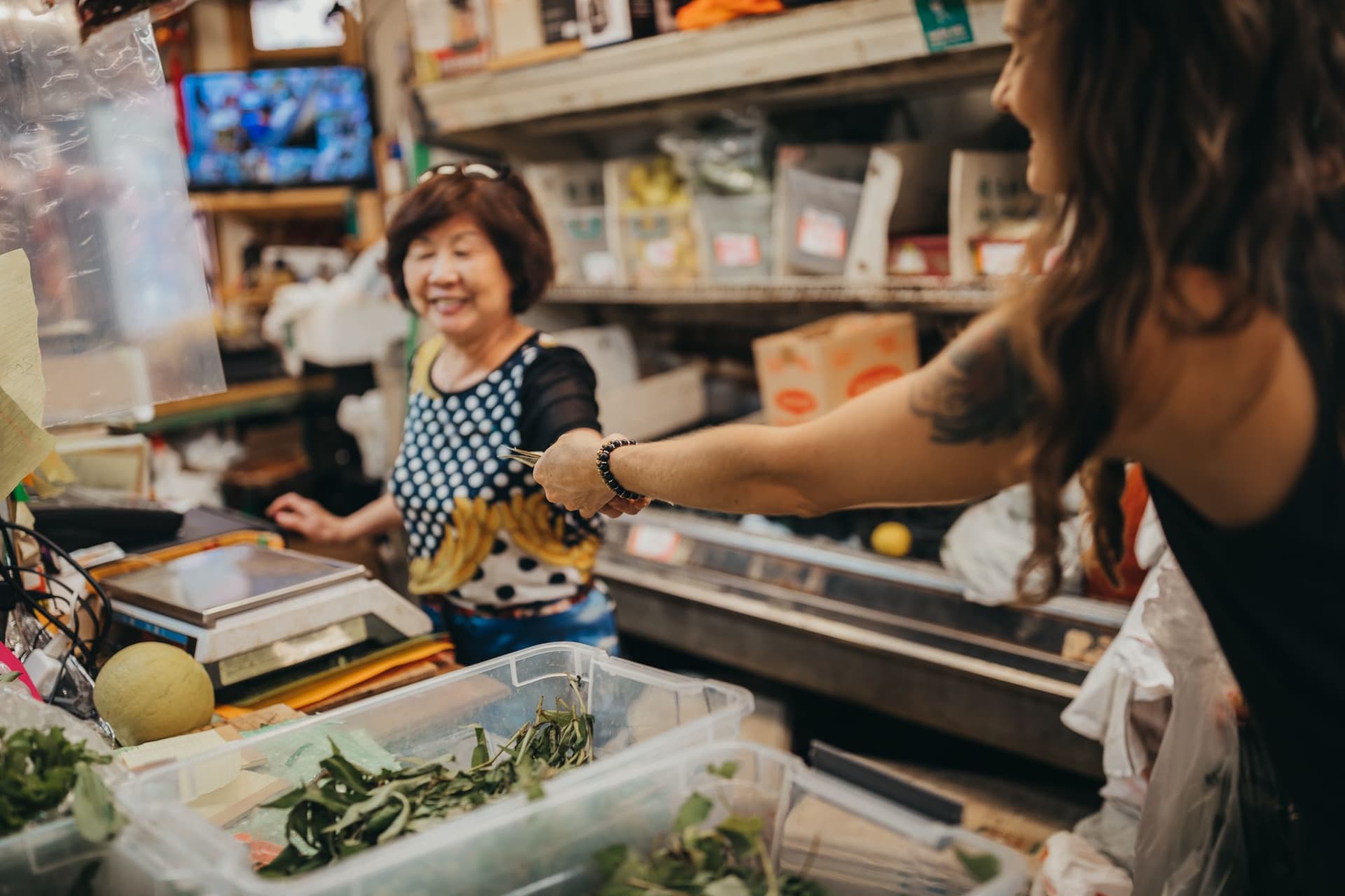 A woman buying groceries in chinatown honolulu oahu hawaii.