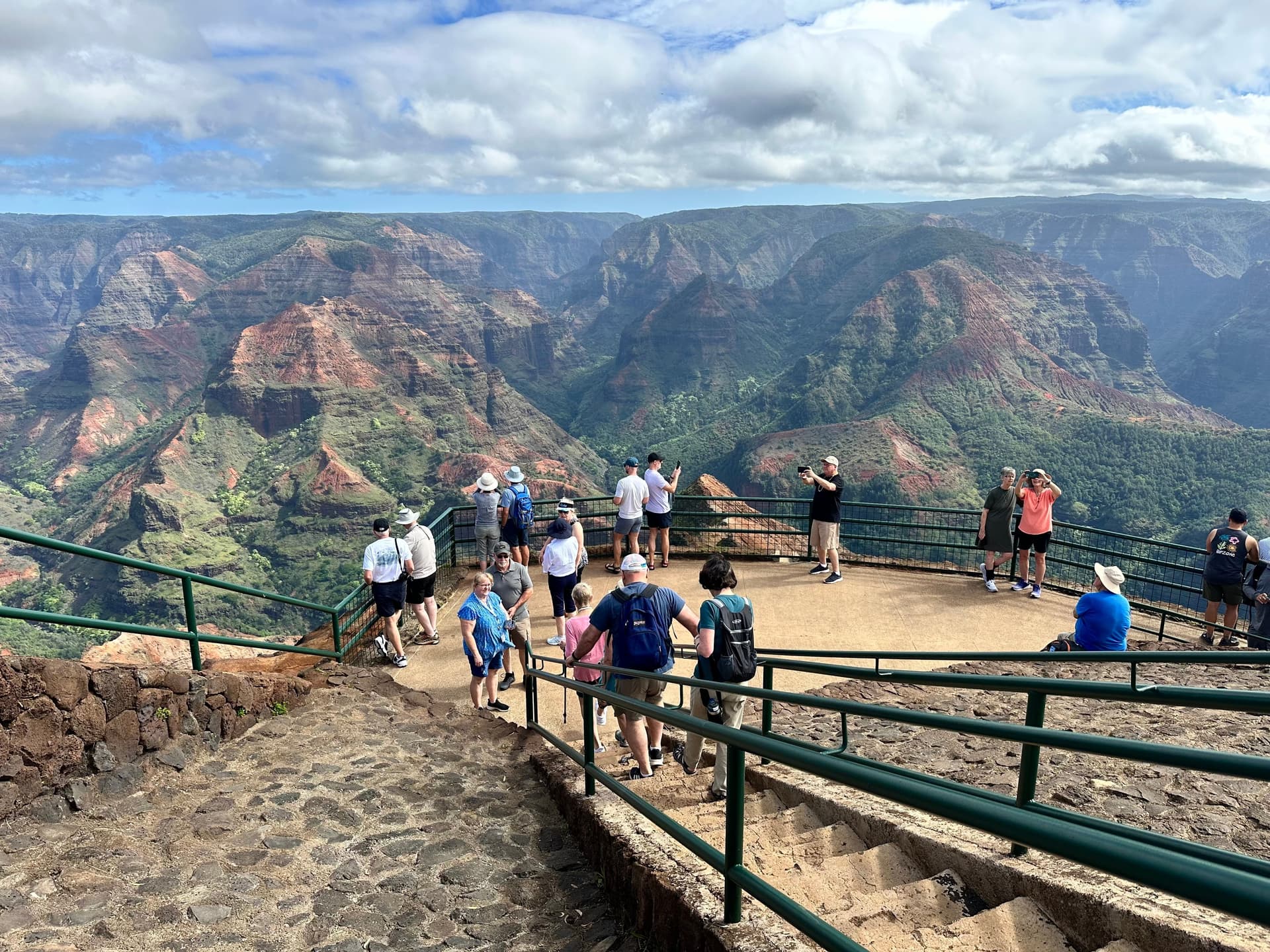 A group of visitors looks out at Waimea Canyon on Kauai, Hawaii.