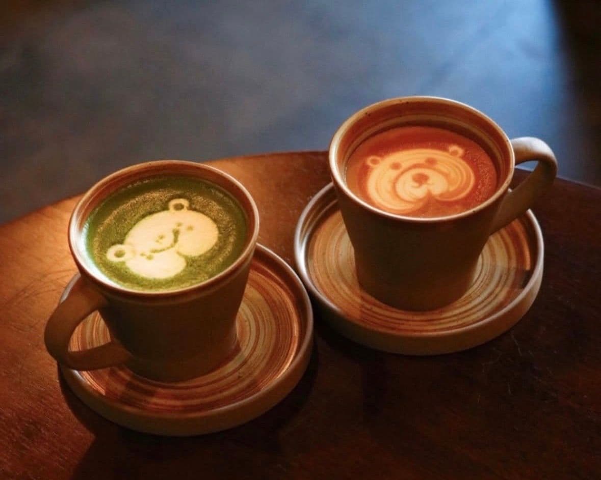 Two lattes with bears drawn in milk foam.