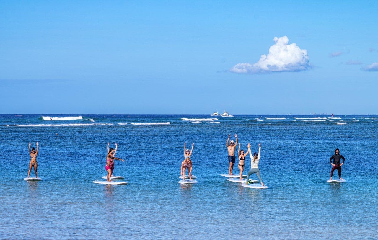 People doing yoga on SUP in the ocean