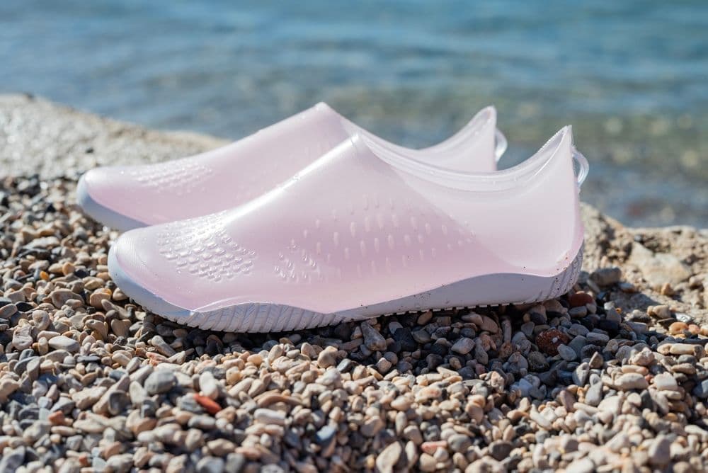 Pair of white water shoes on a rocky beach