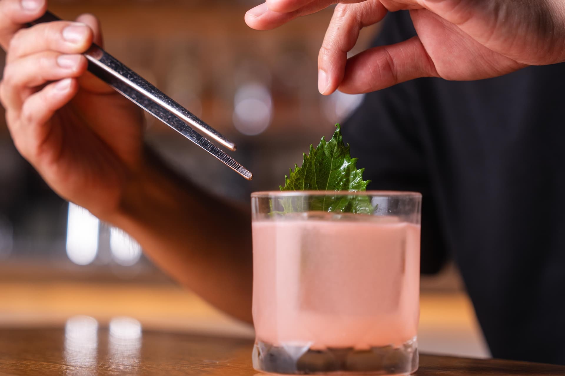 Hands garnishing a cocktail