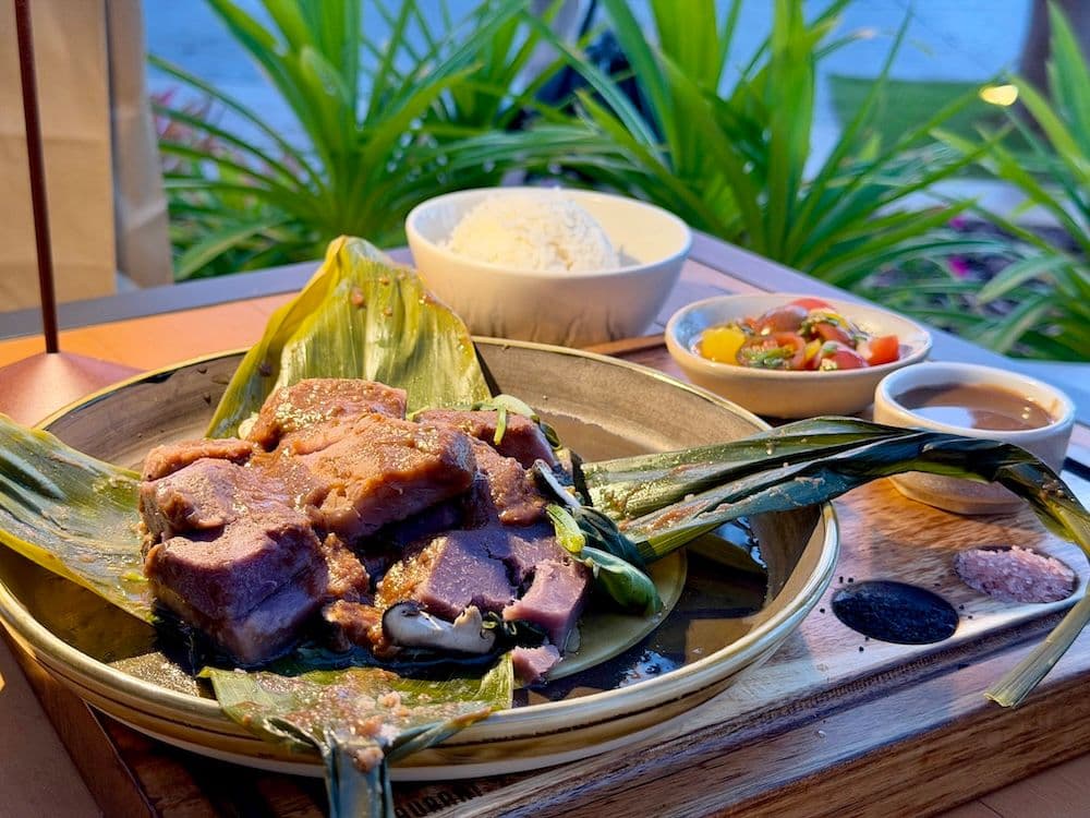 A plate of taro lau lau with rice, lomi lomi and poi at Ko restaurant on Maui Hawaii.