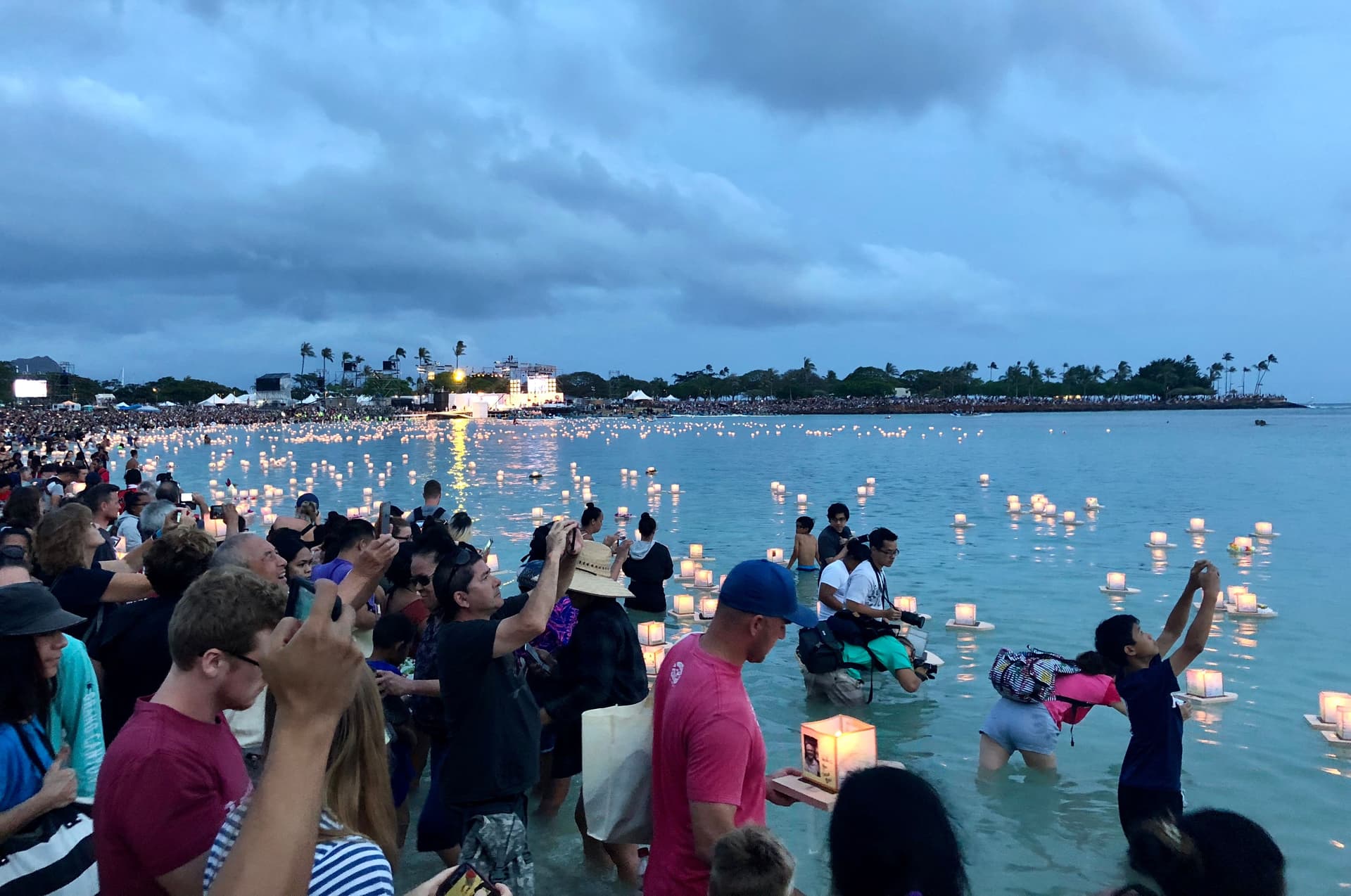 Thousands of people floating lanterns into the ocean at ala moana beach on oahu hawaii.