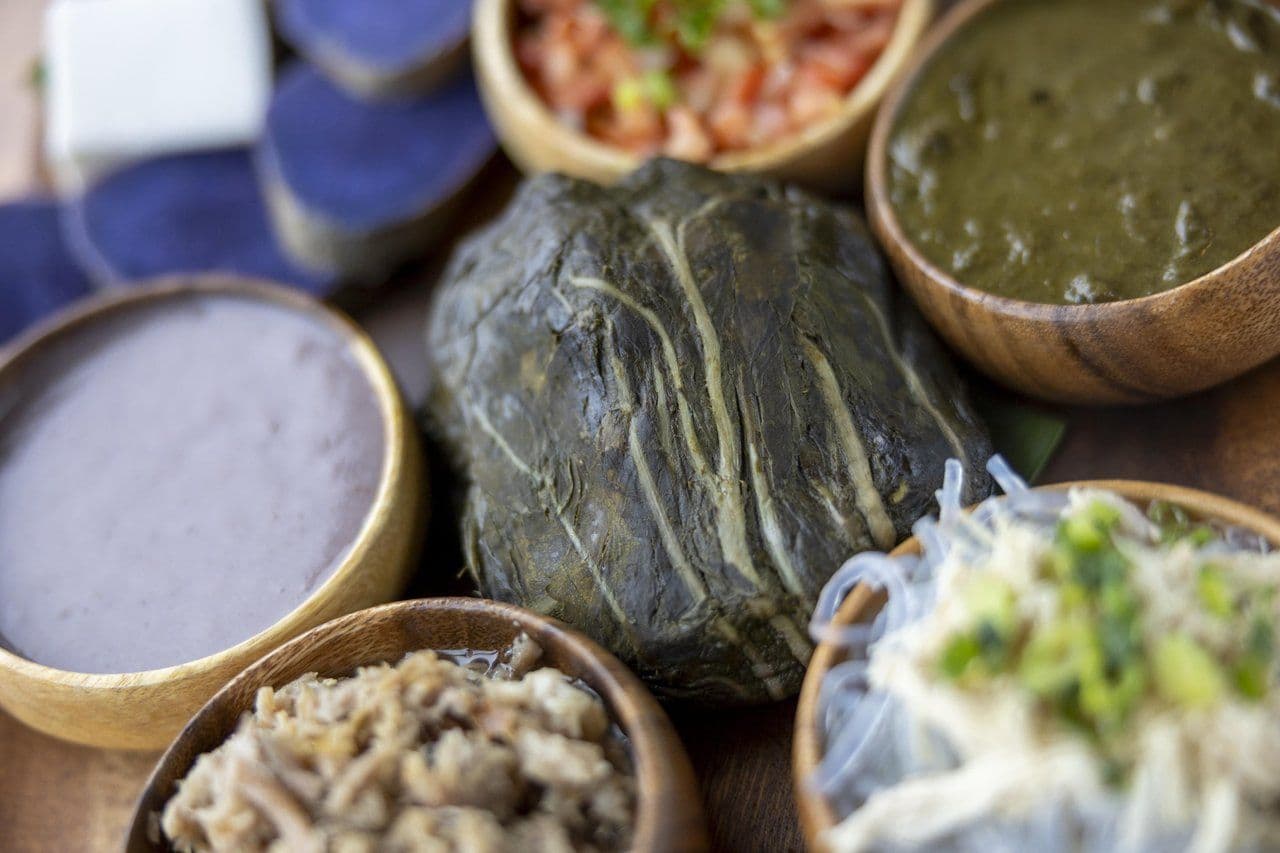 Laulau, surrounded by typical accompaniments including poi, lomi lomi salmon and steamed sweet potato. Photo by Marco Garcia. t