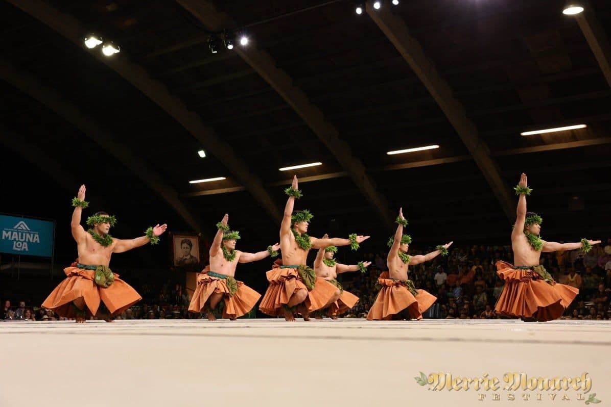 Hula dancing men in pose on stage