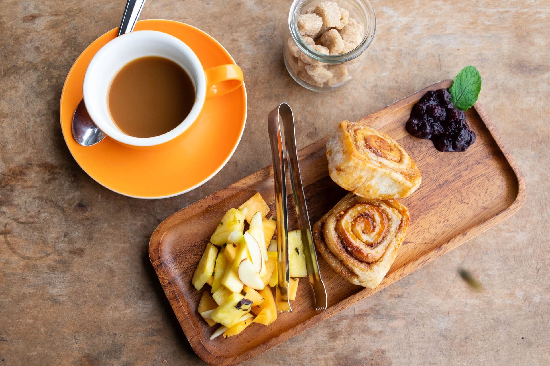 Cup of coffee with cinnamon bun and fruit on Oo Farm's Seed-to-Cup Coffee, Brunch and Farm Tour on Maui, Hawaii.