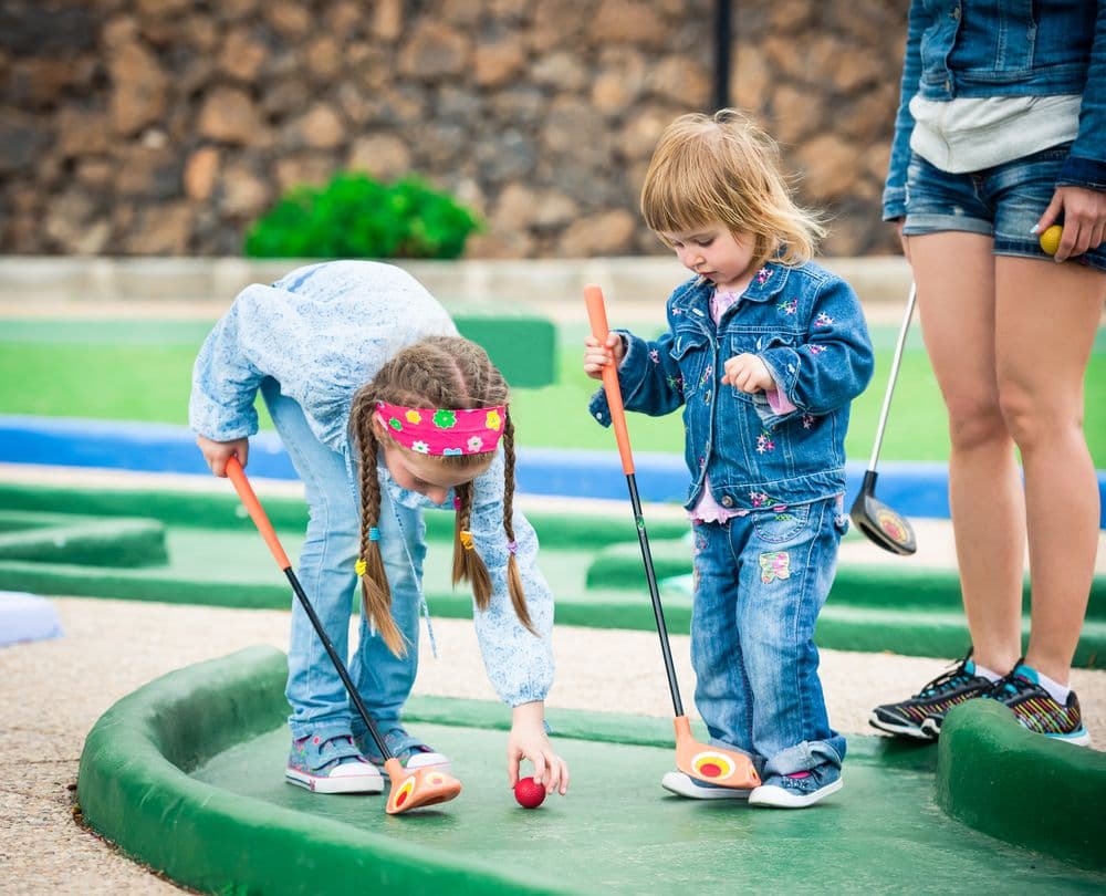 Little kids playing miniature golf