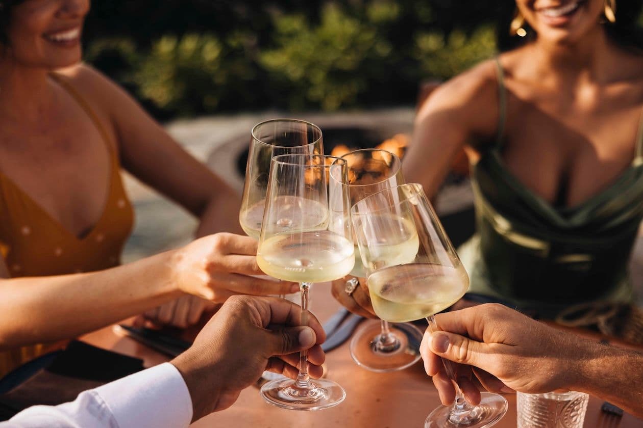 Four people clinking champagne glasses.