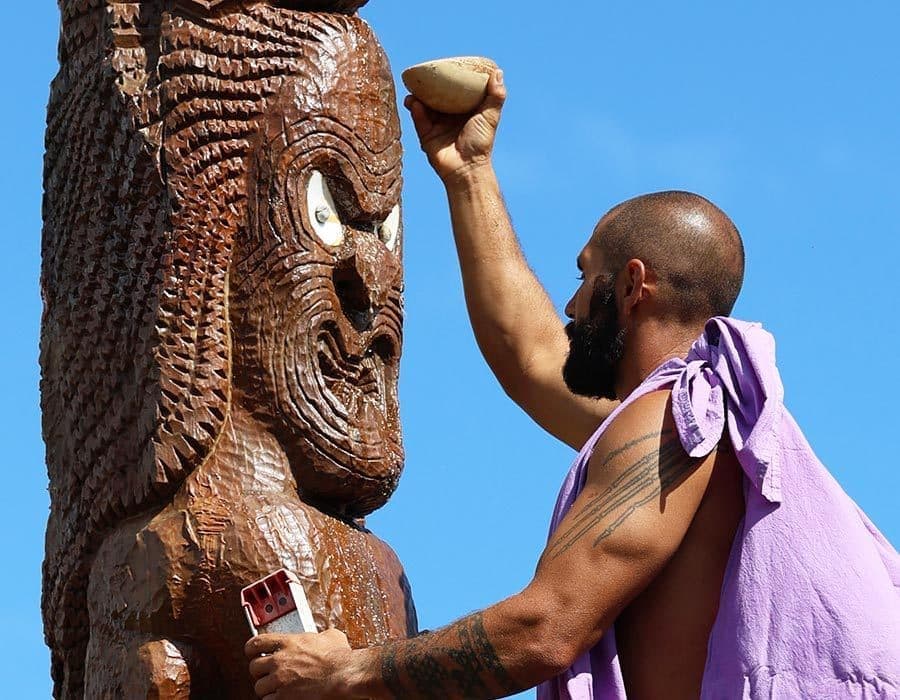 man and hawaiian statue