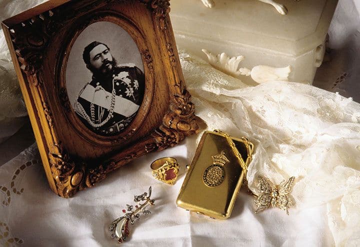 King Kalakaua was the last reigning King of the Hawaiian Kingdom. Show here is a photo of His Majesty King Kalakaua, his ring, and pieces of jewelry belonging to his wife, Queen Kapiolani, including her diamond broach, compact, and diamond butterfly pin with wings that will flutter gently when moved. (Hawaii Visitors and Convention Bureau (HVCB)/Linda Ching)