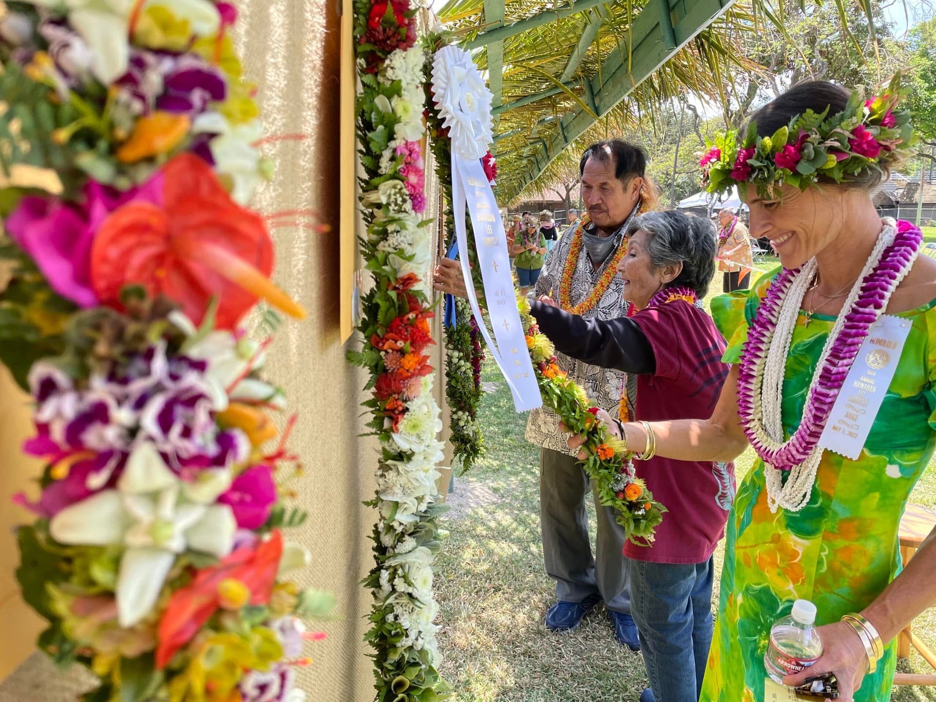 People looking at Hawaiian leis.