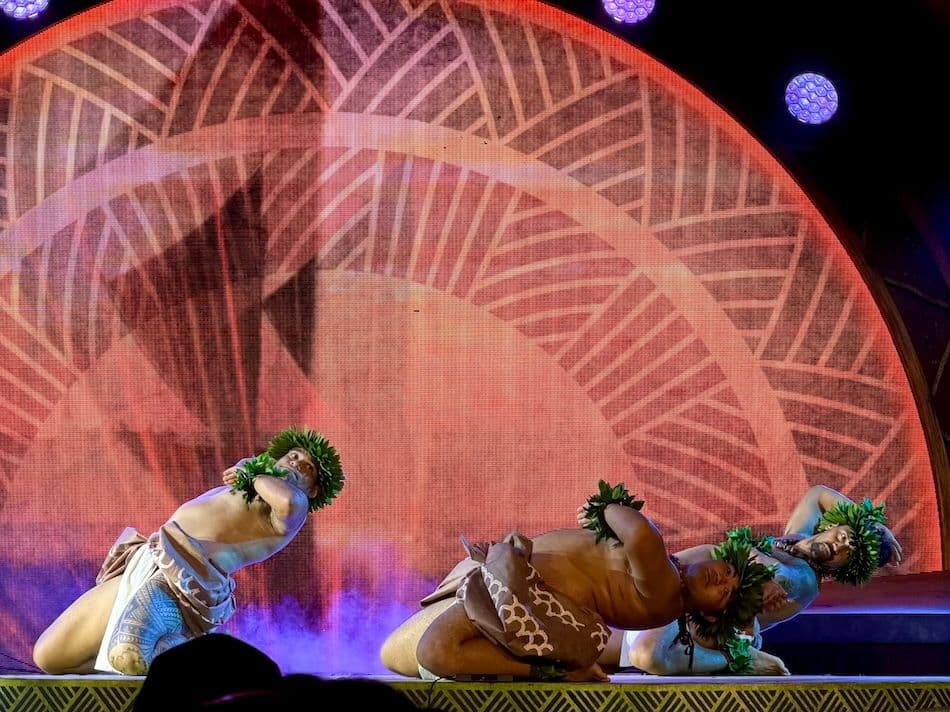 Three male hula dancers performing on stage in oahu hawaii.