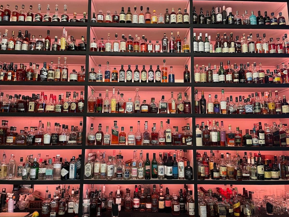 A bar with a wall full of liquor