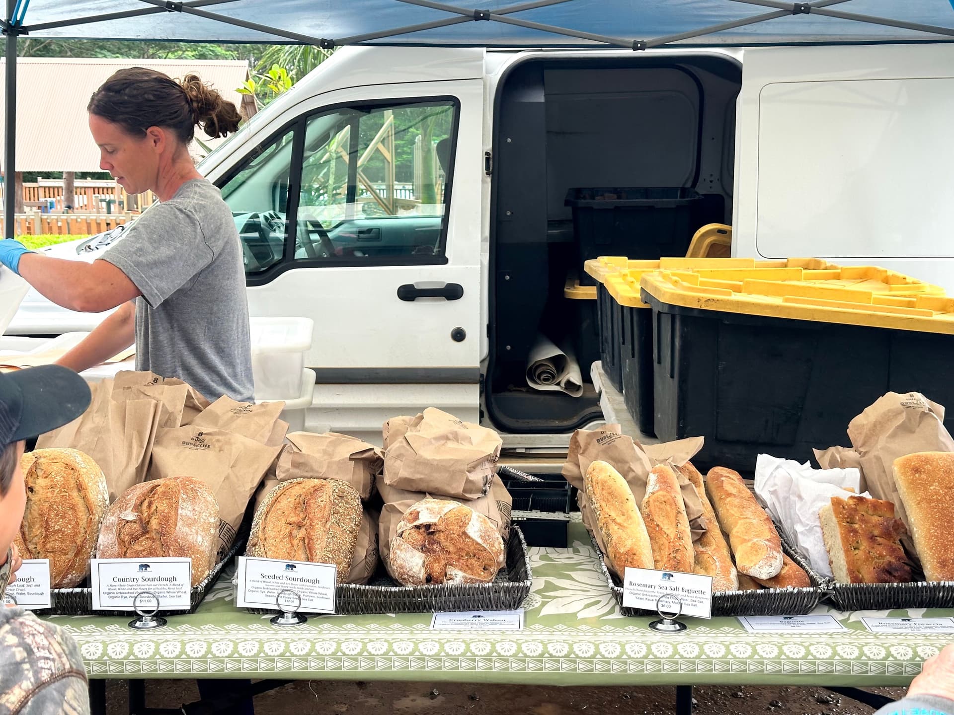 Vendor selling sourdough bread at farmers market on Kauai.